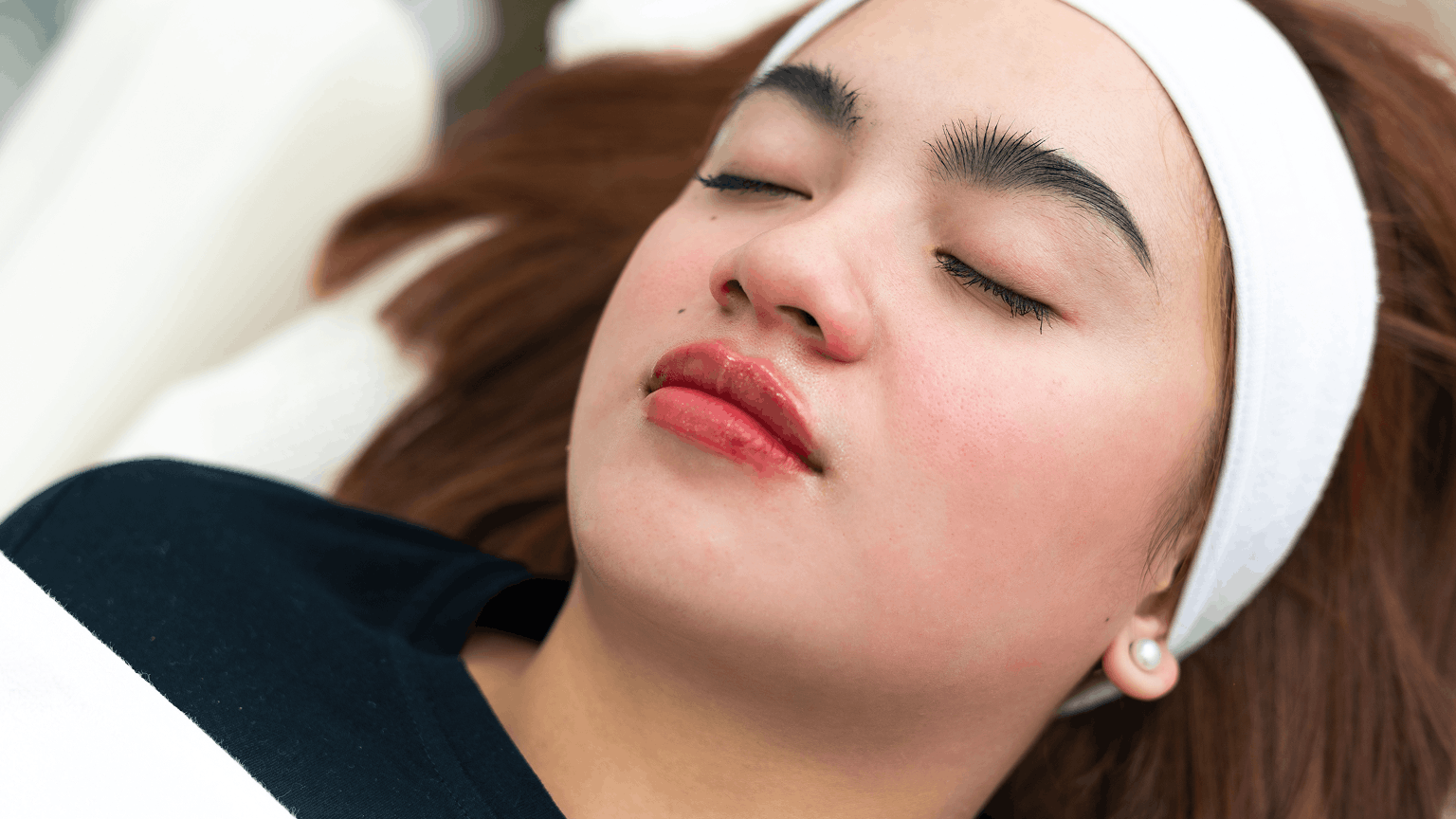 Woman receiving lip filler treatment with smooth, plump and hydrated lips in a clinic